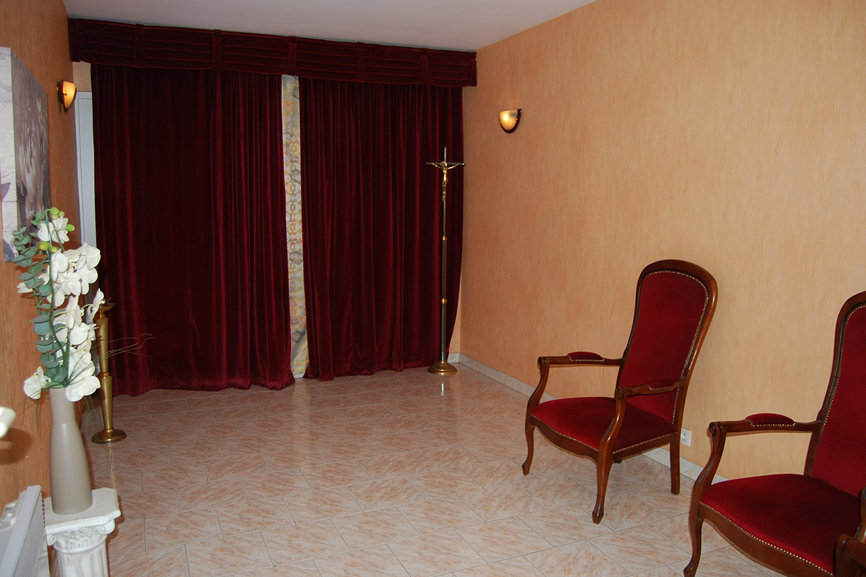 Salle de recueillement avec rideaux rouges au funérarium Pompes Funèbres des Landes