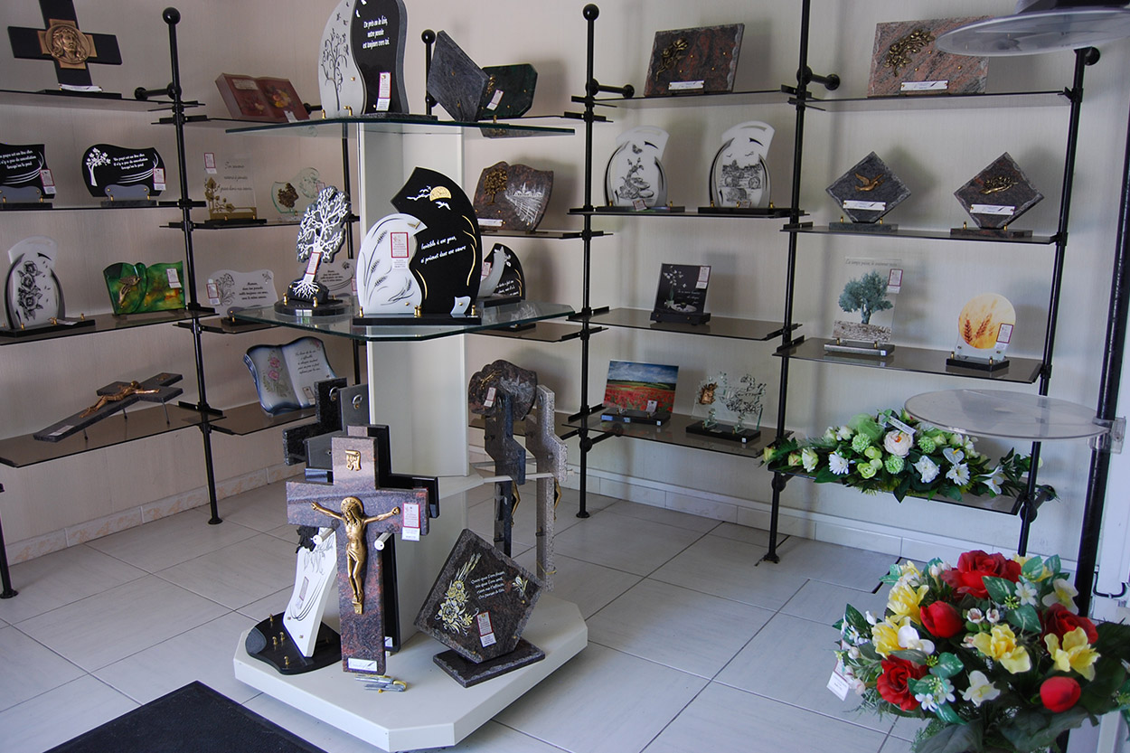 Plaques funéraires, fleurs de deuil et articles funéraires présentés à Tartas